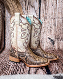 Side view of the Sundance Python Corral Boots in a wood backdrop.