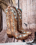 Side view of the Rodeo Afterglow Corral Boots in a wood backdrop.