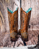 Back view of the Saddleback Shadow Corral Boots in a wood backdrop.