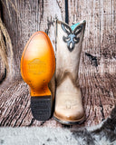 Front and bottom of the Dustbowl Drifter Corral Boots with a wood backdrop.