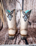 Back view of the Dustbowl Drifter Corral Boots with a wood backdrop.