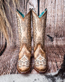 Front view of the Phantom Dune Corral Boots with a wood backdrop.
