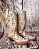 Side view of the Phantom Dune Corral Boots with a wood backdrop.