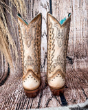Back view of the Phantom Dune Corral Boots with a wood backdrop.