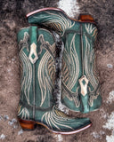 The Mystic Pine Corral Boots displayed on cowhide.