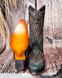 Front and bottom of the Mystic Pine Corral Boots with a wood backdrop.
