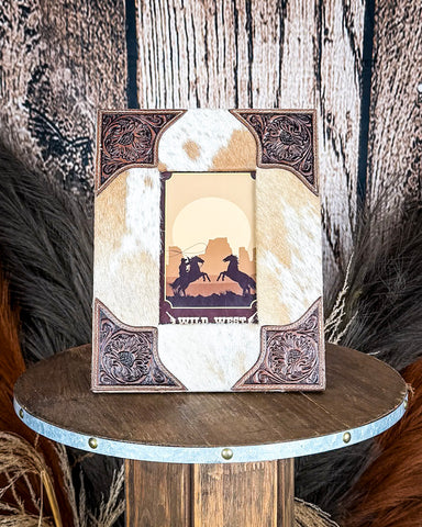 Front view of the Myra Bag - Tumbleweed Trail Photo Frame in Brown and White on a wood background.