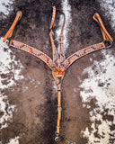 The Turquoise Sunflower Tooled Breast Collar and Single Ear Headstall displayed on cowhide.