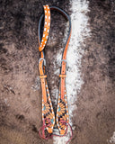 Side view of the Turquoise Sunflower Tooled Single Ear Headstall displayed on cowhide.