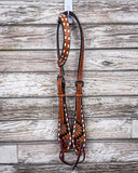 The Turquoise Sunflower Tooled Breast Single Ear Headstall on a wood backdrop.
