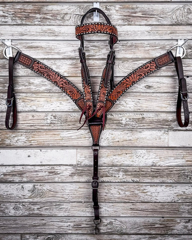 Floral and Sunflower Tooled Breast Collar and Headstall displayed on a wood background.