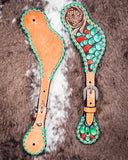 Painted Cactus Ladies Spur Straps displayed on cowhide.