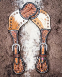 Cowhide and Brass Accent Ladies Spur Straps displayed on cowhide.