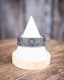 The Sable Sun Cuff Fashion Bracelet displayed on table in front of wood backdrop