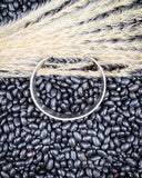 The Sable Sun Cuff Fashion Bracelet displayed on black pebbles and wheat.