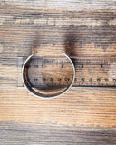 The Sable Sun Cuff Fashion Bracelet displayed on wood.