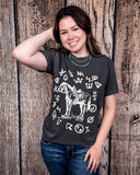 The Branded Pony Graphic Tee modeled and styled In front of a wood backdrop.