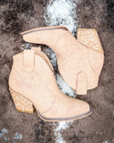 Dangerous Ankle Bootie in Light Tan displayed on cowhide background.