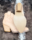 Dangerous Ankle Bootie in Light Tan displayed on cowhide background.