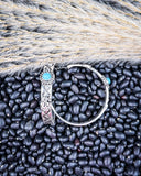 Thunderbird Hoop Fashion Earrings displayed on black pebbles and wheat background.