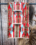 Ojo Caliente Towels displayed on a rod in front of wood background.