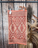 Navajo Adobe Towels displayed on rod in front of wood background.
