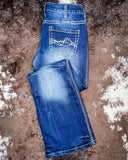 Folded blue jeans on a textured brown surface