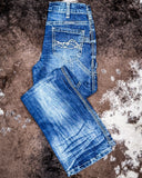 Folded blue jeans on a textured brown surface