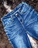 Blue jeans on a textured brown surface