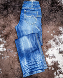 Folded blue jeans on a textured brown surface