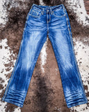 Blue jeans on a textured brown surface