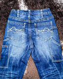 Blue jeans with decorative stitching on a textured surface