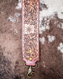 Decorative leather purse strap with floral patterns on a textured surface