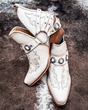Side and front view of the Western Ember Booties in White displayed on cowhide.