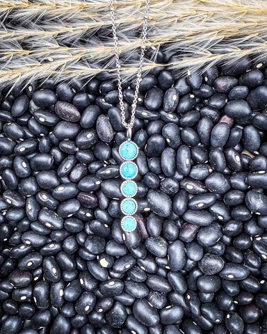 Necklace with a turquoise pendant on black beans