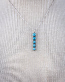 Necklace with turquoise stones on a textured cream background