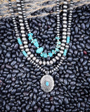Necklace with faux turquoise stones and silver pendant on black beans