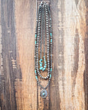 Layered necklace with faux turquoise accents on a ruler on a wooden surface