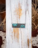Necklace with faux turquoise floral designs on a wooden surface