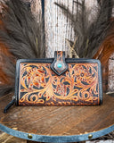 Handcrafted leather wallet with intricate designs on a wooden surface