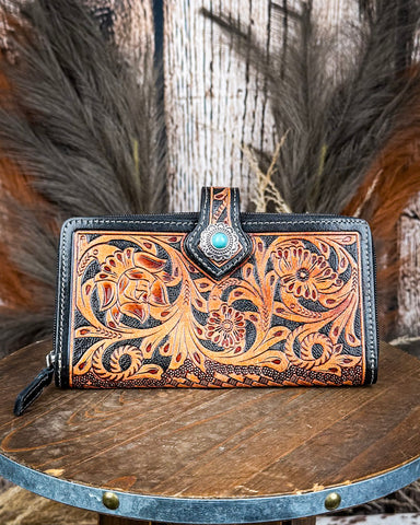 Handcrafted leather wallet with intricate designs on a wooden surface