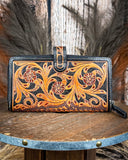 Handcrafted leather wallet with floral patterns on a wooden surface