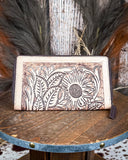 Leather wallet with floral embossing on a wooden surface
