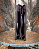 Brown leather wallet open on a wooden surface with a natural background
