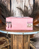 Pink jewelry box with decorative elements on a wooden surface