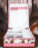 Pink and brown jewelry box with compartments on a wooden surface