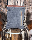 Back of purse with fringe details on a wooden surface