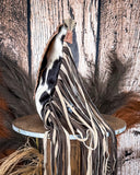 Leather fringe purse on a wooden stool against a rustic wooden wall.