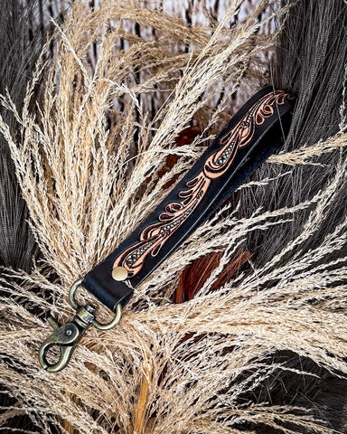 Decorative black key fob on a natural background