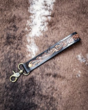 Decorative leather key fob with on a textured brown surface